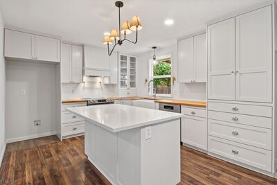 Kitchen with tall pantry cabinets, a large island and natural light coming in above the sink