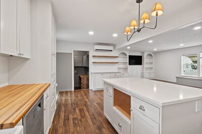 Kitchen with handmade butcher block countertops, glass front cabinet doors and a chandelier over the island